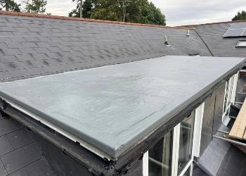 A newly installed grey GRP fibreglass flat roof on a residential extension, demonstrating a seamless, waterproof finish by FRR Midlands Ltd.